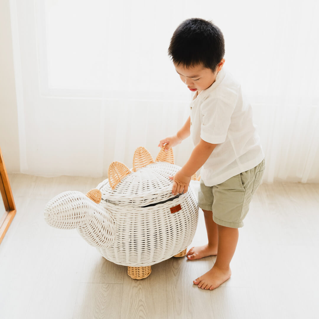 Child opening a white dinosaur rattan storage basket by MOMIJI.
