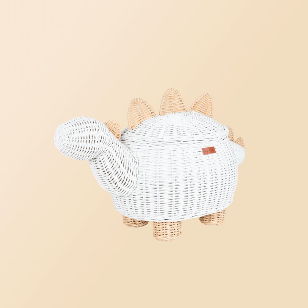 Tilted side view of the white dinosaur rattan storage basket by MOMIJI.