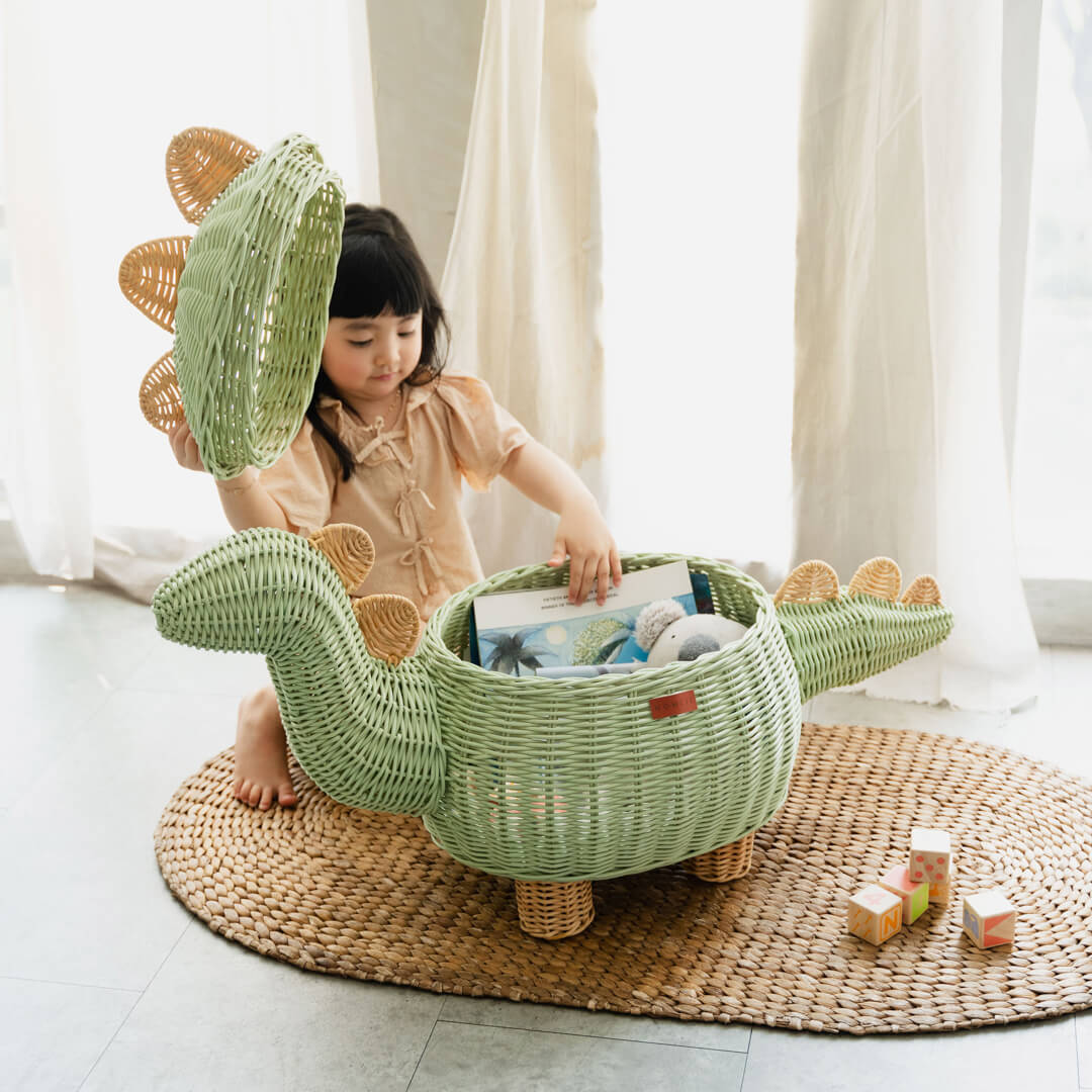 A child playing with the Mint Green Dinosaur Storage Rattan Basket by MOMIJI in extra large size.