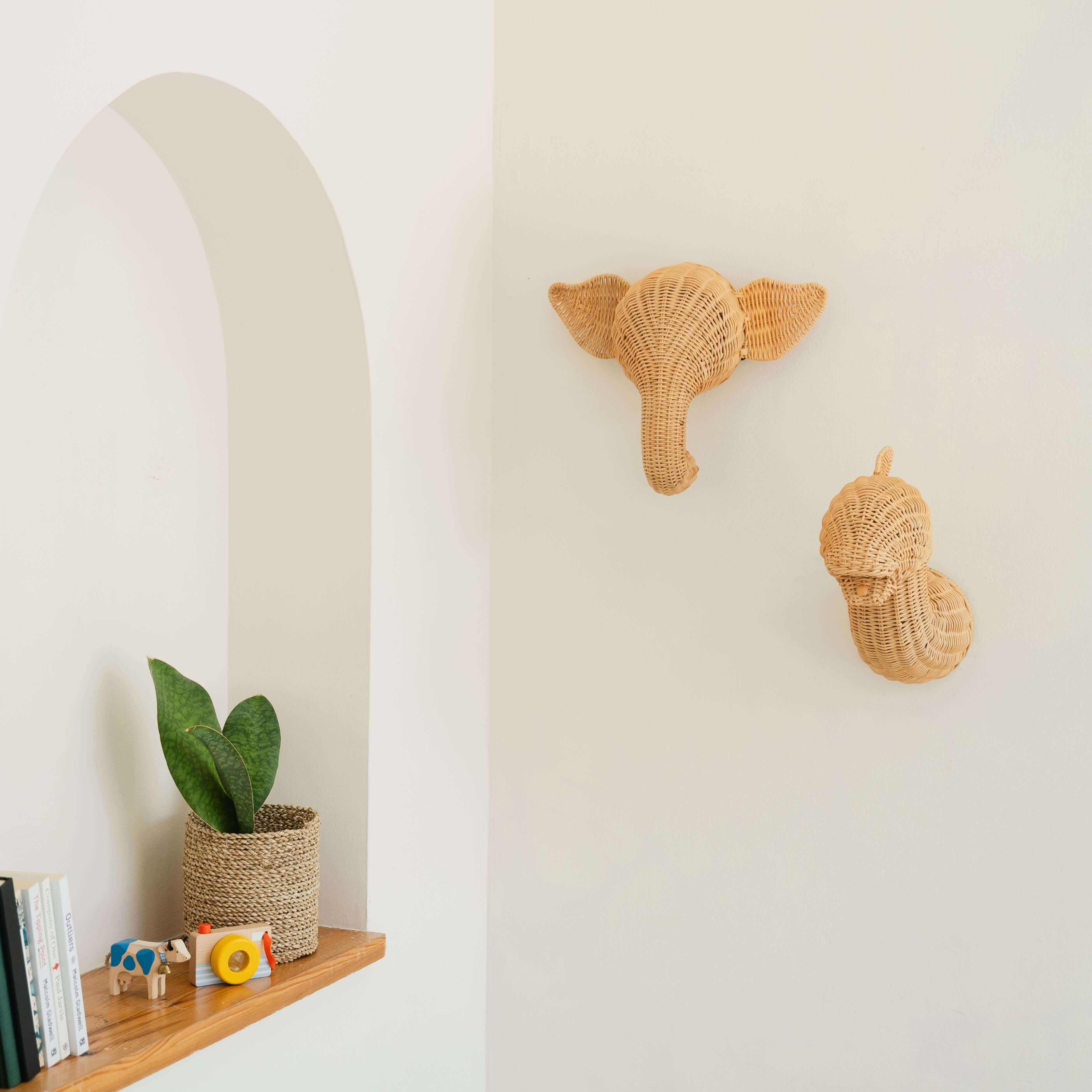 Elephant and dinosaur wall decor by MOMIJI mounted on a decorative wall.