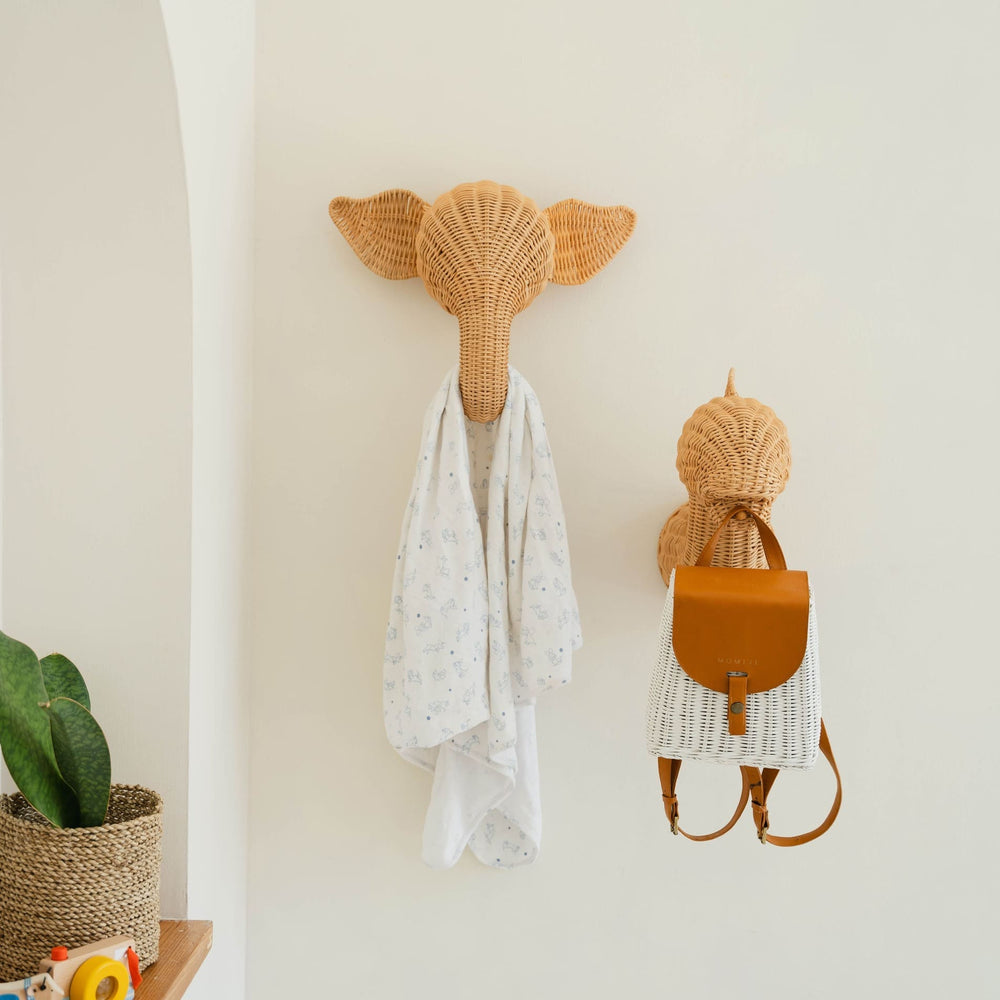 Elephant and dinosaur wall decor by MOMIJI hanging a white shirt and a bag on a decorative wall.
