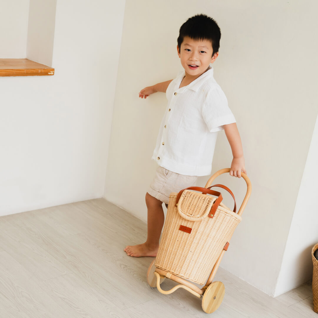 Happy child pushing the Eric Kids Shopping Trolley by MOMIJI indoors.