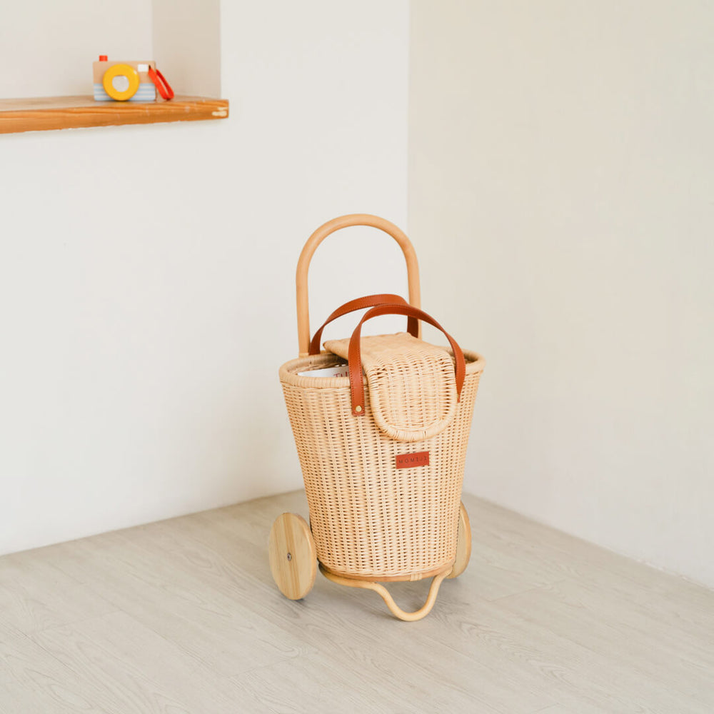 Front view of the Eric Kids Shopping Trolley by MOMIJI styled indoors with decorative elements.