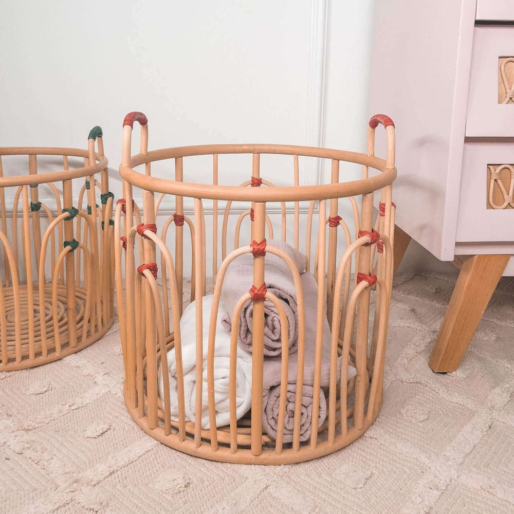 Large handcrafted rattan wicker Floret Basket by MOMIJI with red binding, filled with rolled towels, with the smaller basket placed beside it.