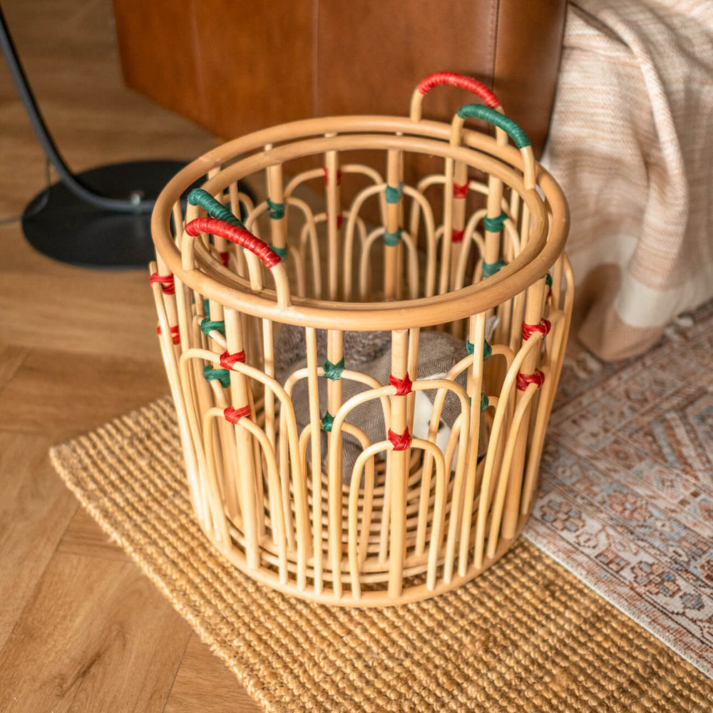 Stacked handcrafted rattan wicker Floret baskets by MOMIJI filled with toys in an indoor setting.