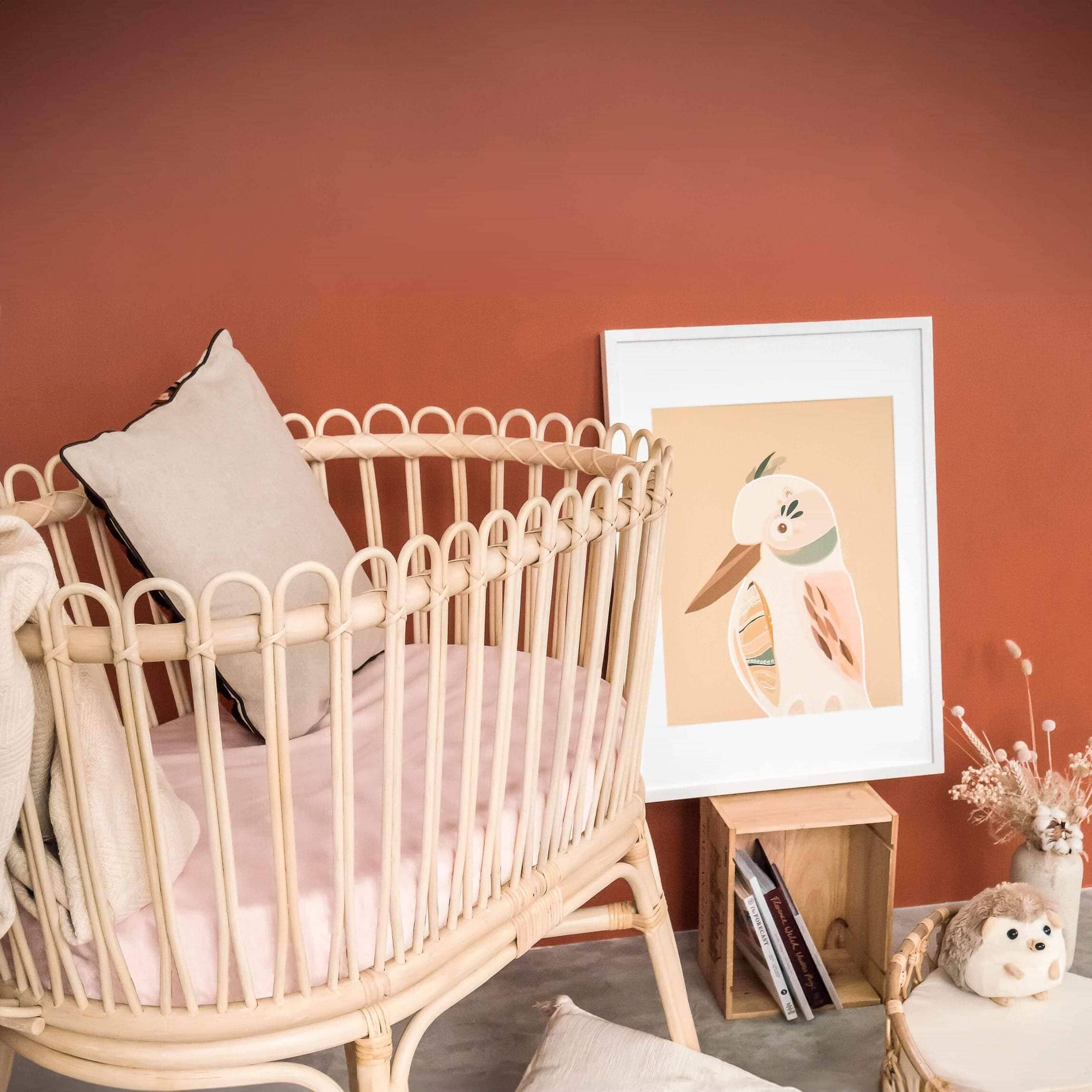 Gerhana Bassinet by MOMIJI styled with pillows and blankets in a room with framed wall art.