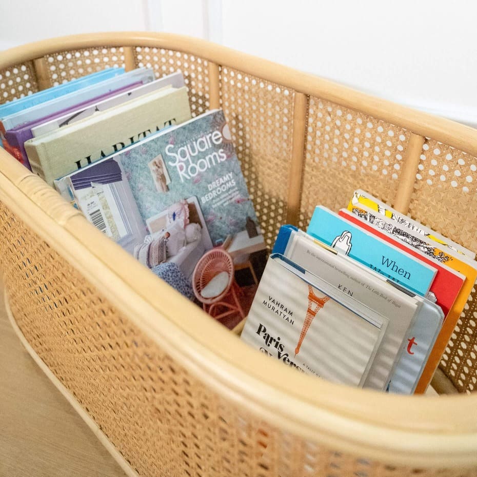 Interior view of the Isle Wicker Plant Stand by MOMIJI showing books stored inside.