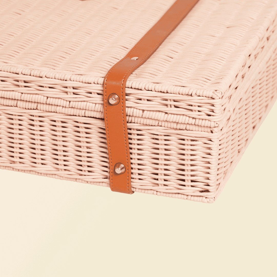 Bottom view of the pink  version of Jasmine rattan Suitcase showing its base structure.