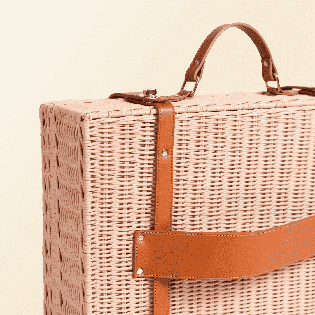 Close-up of the back strap attachment on the handcrafted rattan and wicker Jasmine Suitcase by MOMIJI in pink finish, with integrated handle and lock.