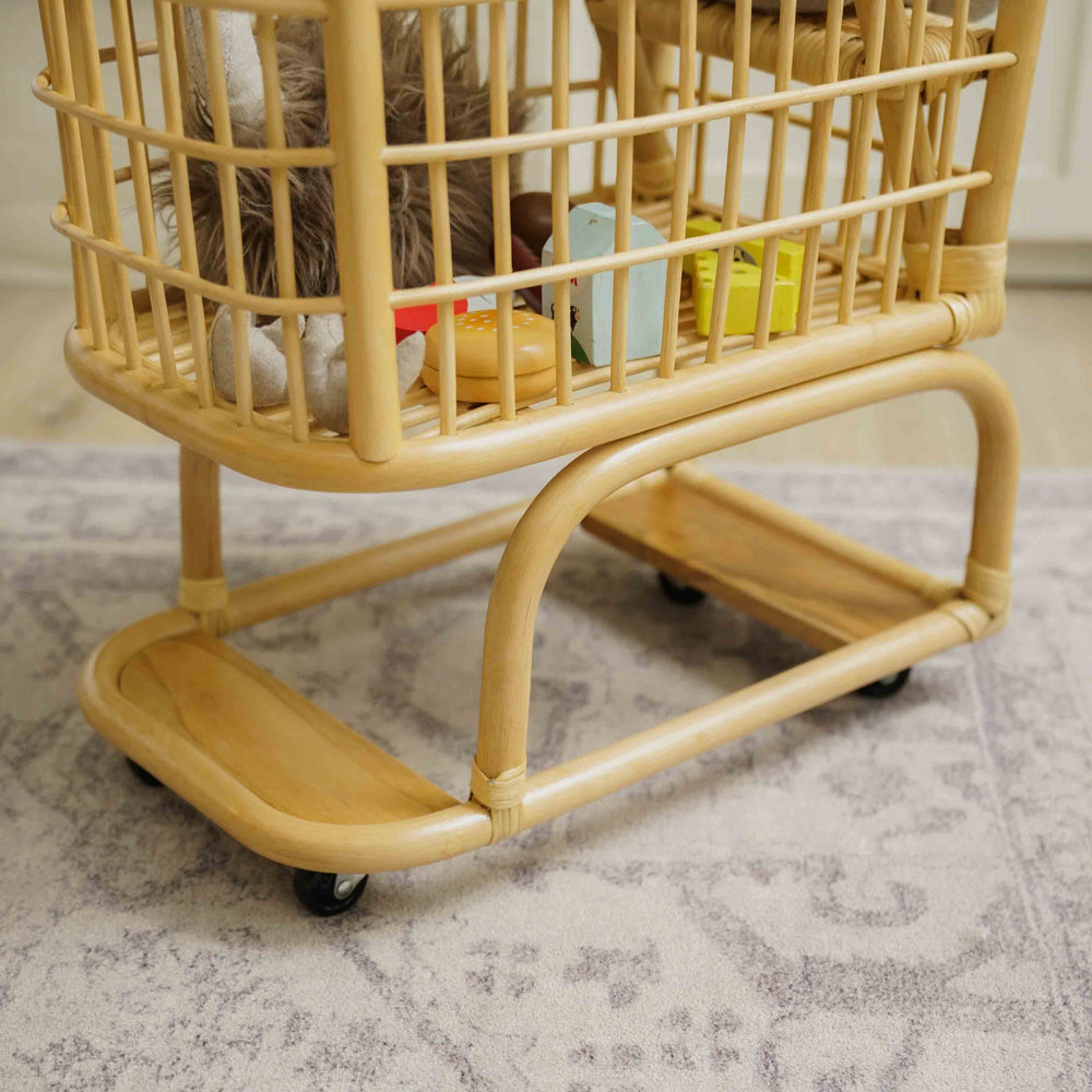 Close up of the base with smooth rolling wheels of a handcrafted wicker rattan Kids Shopping Cart designed for stability and easy movement