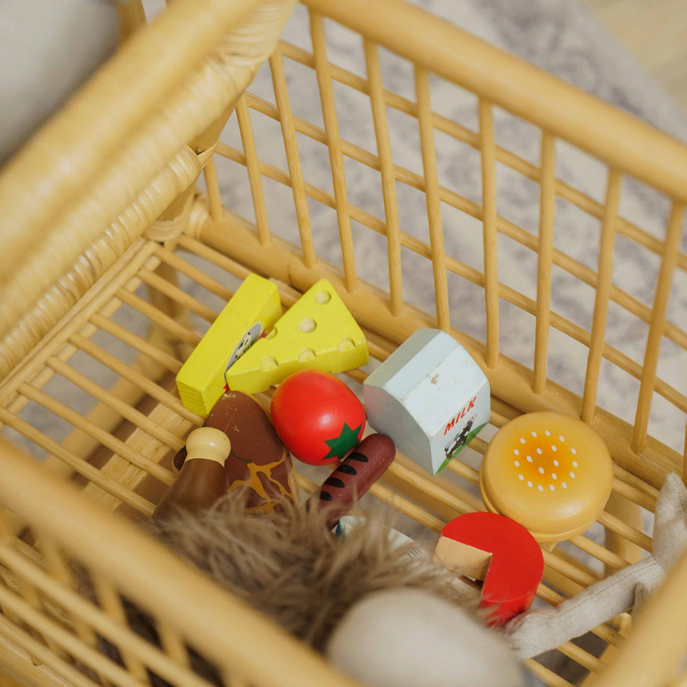 Handcrafted wicker rattan Kids Shopping Cart by MOMIJI with a spacious basket filled with pretend grocery toys