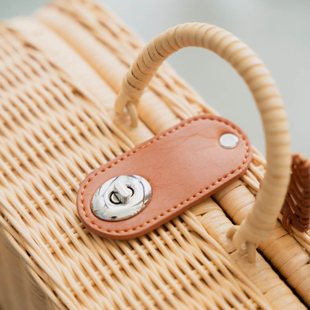 Close-up of the lock and the handle detail on the handcrafted rattan Kitty Kids Suitcase by MOMIJI.