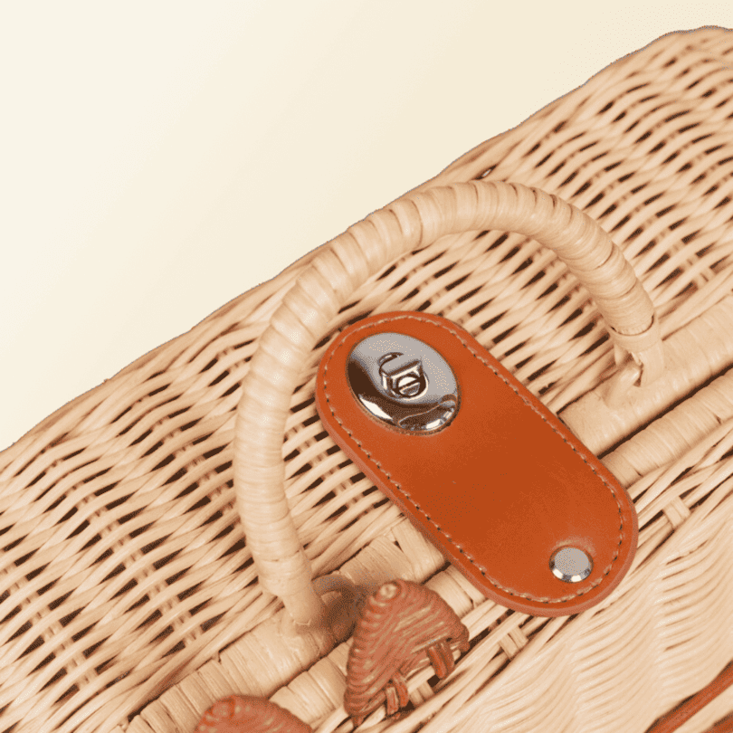 Close-up of the handle and lock on the handcrafted rattan and wicker Kitty Kids Suitcase by MOMIJI.