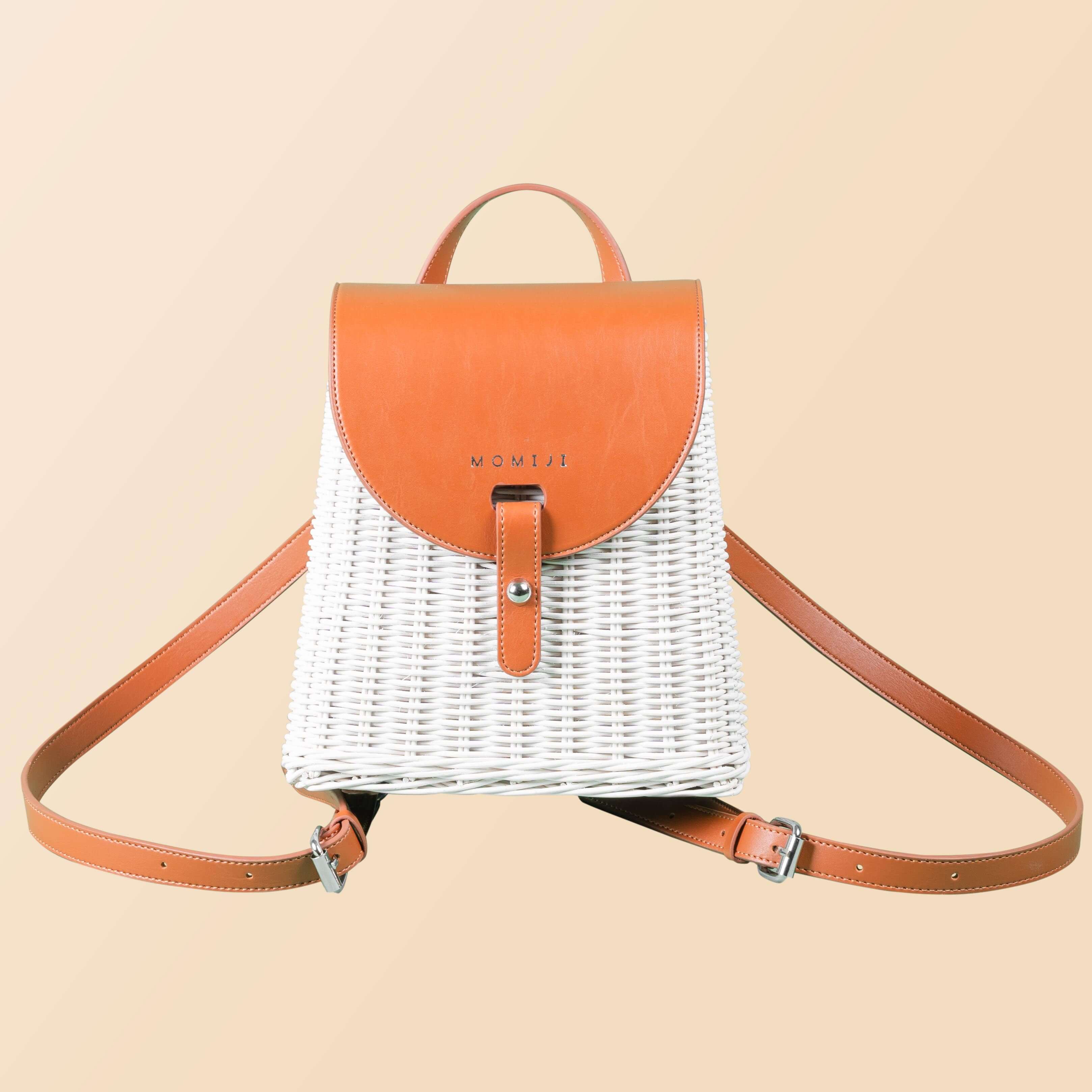 Front view of the handcrafted rattan Layla Backpack by MOMIJI, showing woven structure and leather shoulder straps.