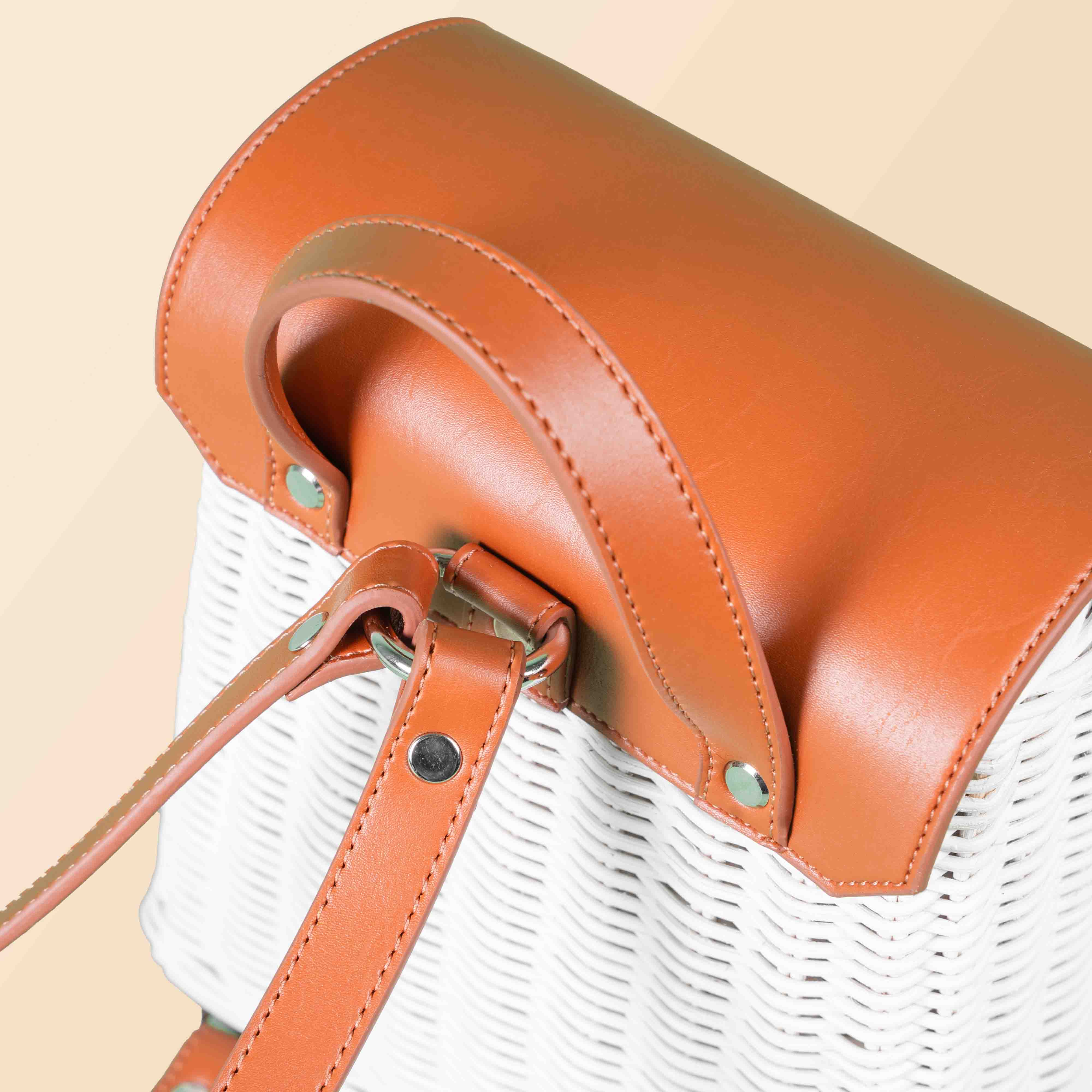 Close-up of the leather strap ring attachment on the handcrafted rattan Layla Backpack by MOMIJI.