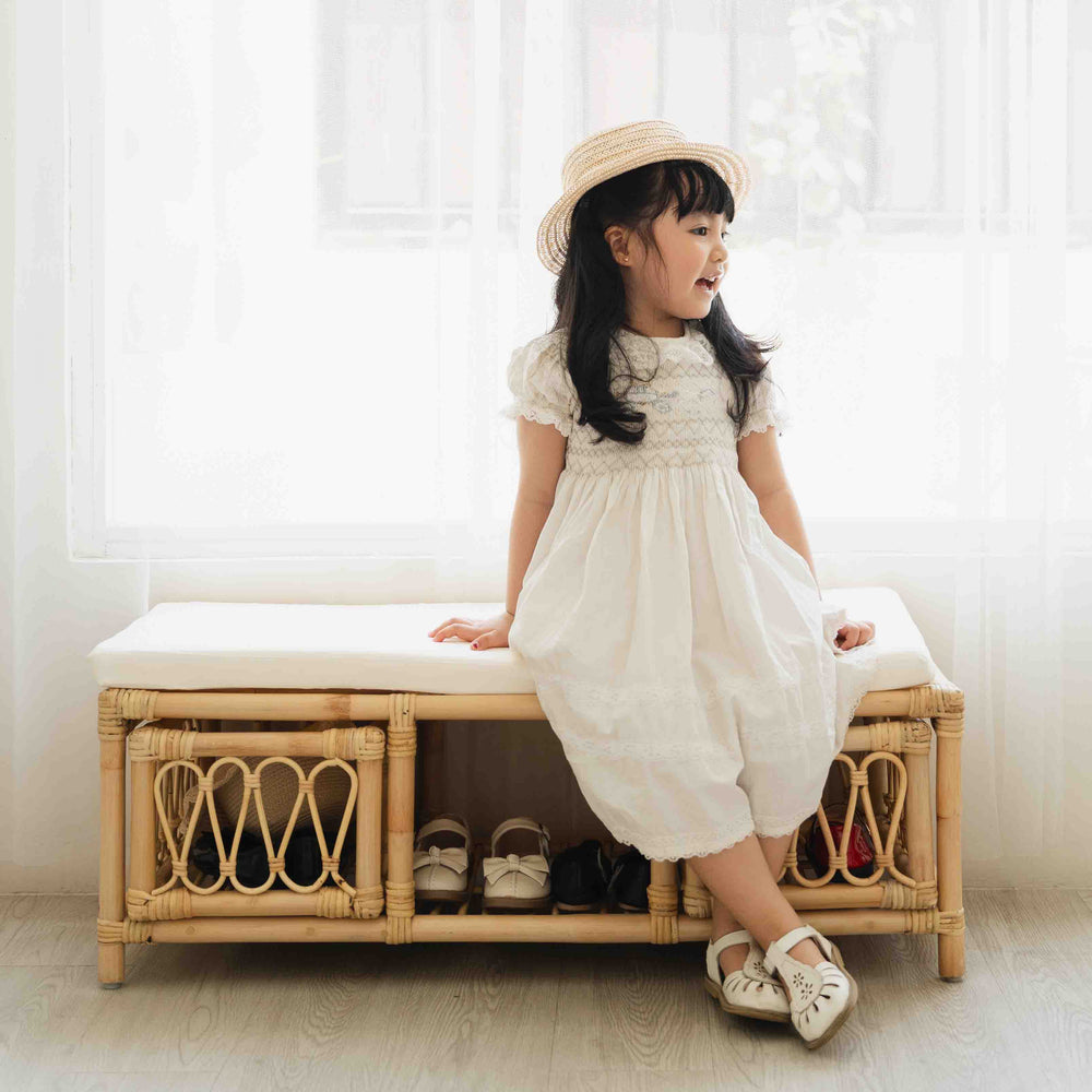 Child sitting on the Luke Kids Bench by MOMIJI with shoes stored in the lower storage area.