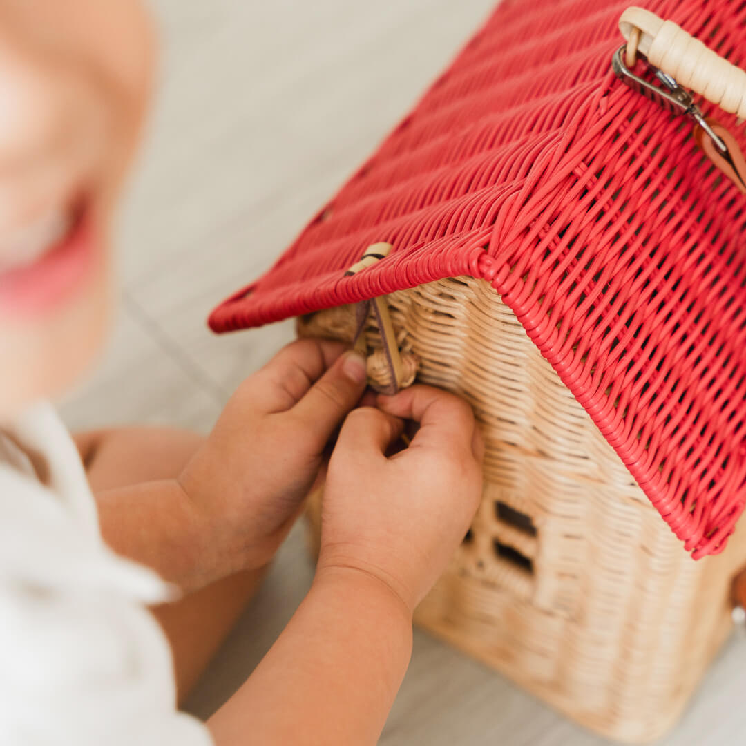 Close-up of a child’s hand holding the top opening of the Lydia House Bag by MOMIJI.