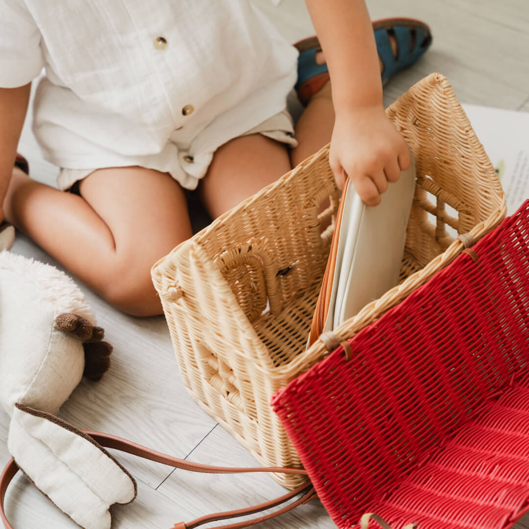 Child placing books inside the Lydia House Bag by MOMIJI.