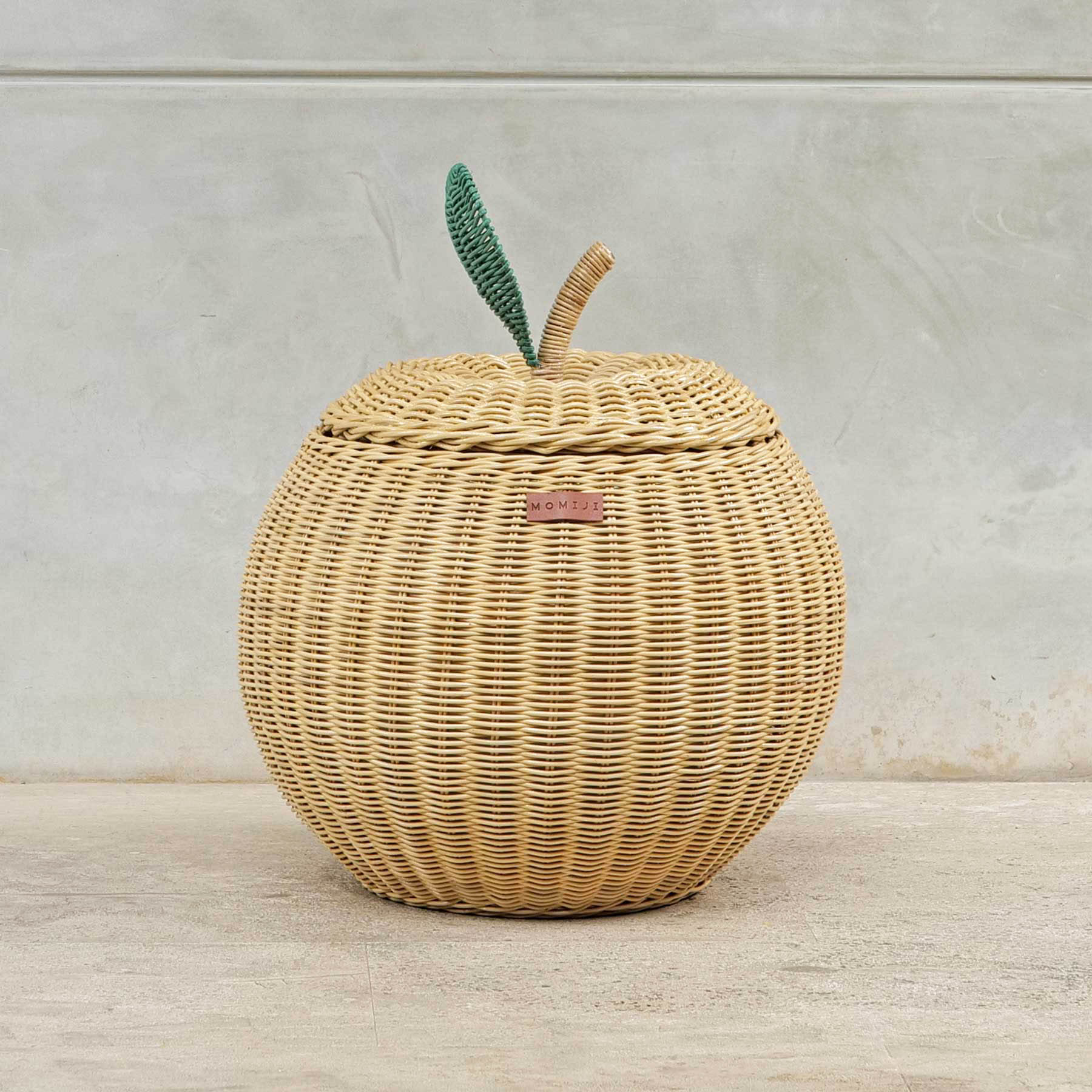 Front view of a medium sized natural apple rattan storage basket by MOMIJI.