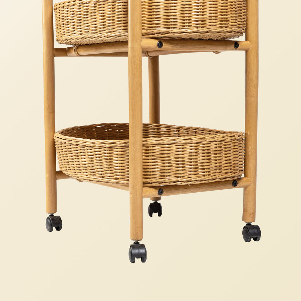 Close-up of handcrafted rattan wicker utility cart leg with wheel and woven basket trays on a beige background