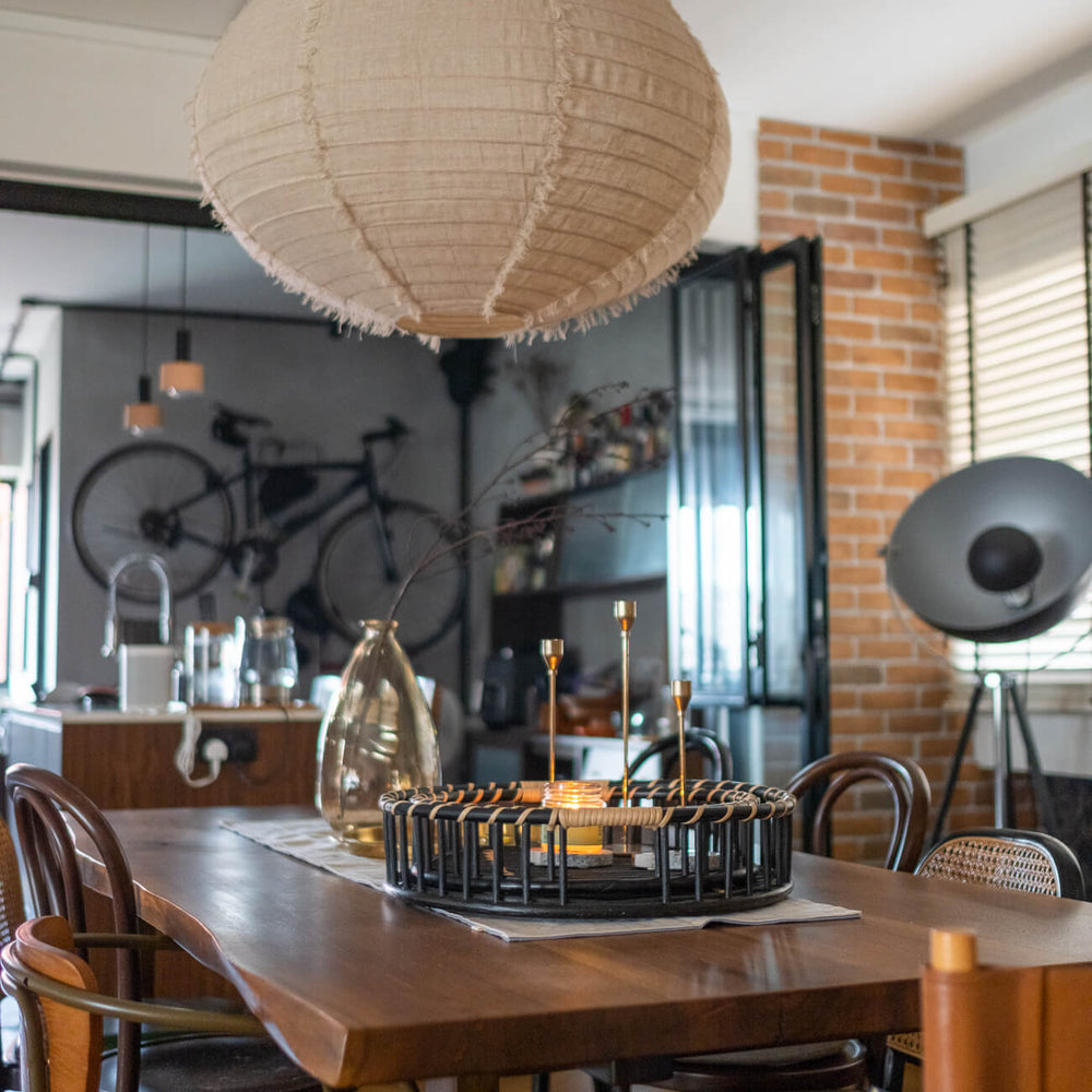 Maru Tray Set by MOMIJI placed on a dining table holding decorative pieces in a cozy room.