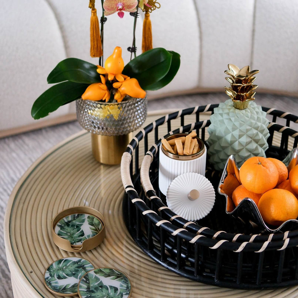Angled side view of the Maru Tray Set by MOMIJI holding fruit bowls and decor on a table.