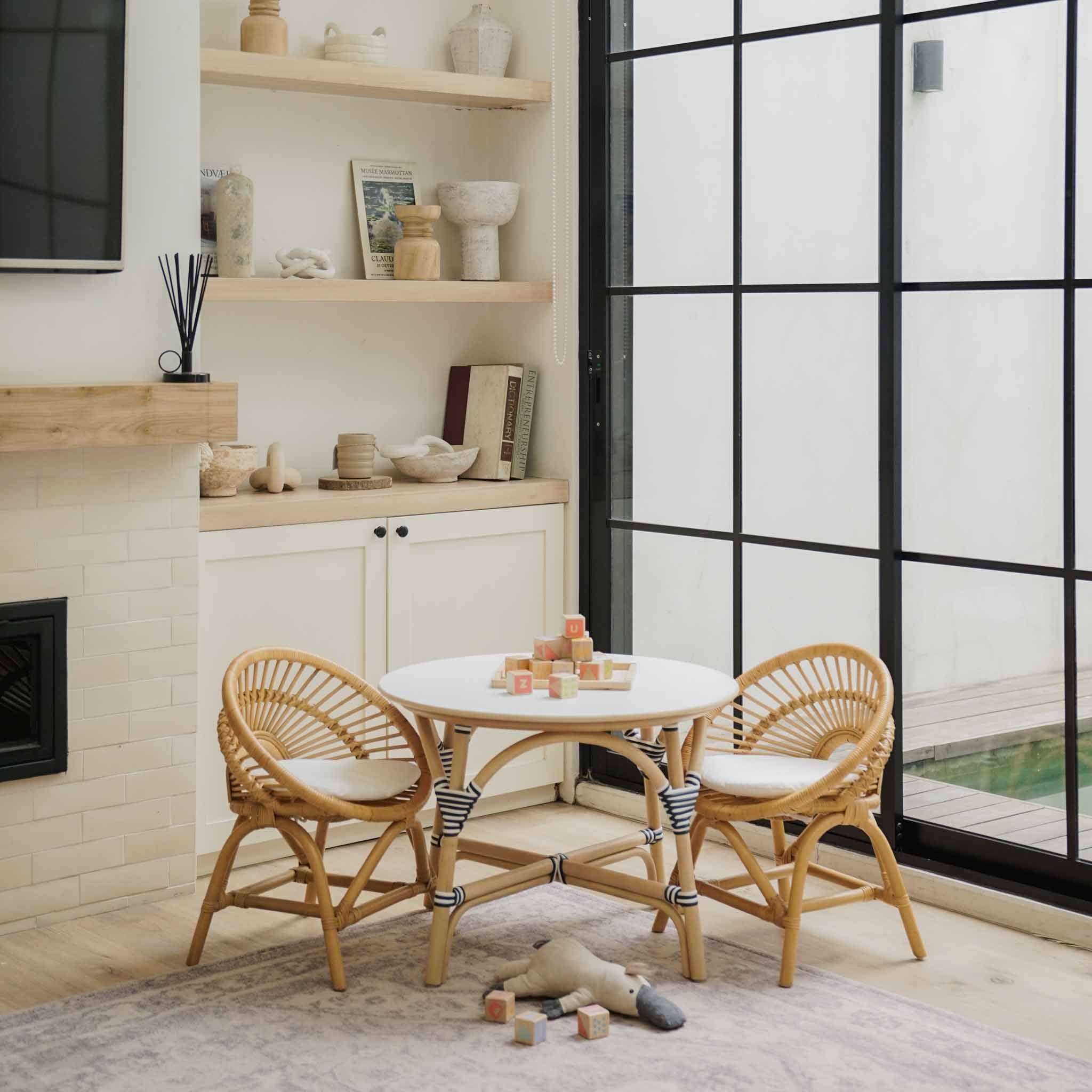 Handcrafted natural rattan Maya Kids Chairs by MOMIJI paired with a matching round Aulia Kids Table, styled in a bright and playful children's room.
