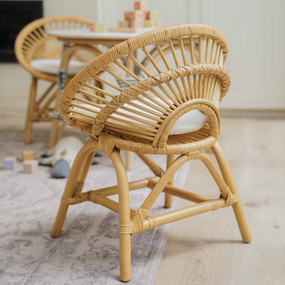 Natural handcrafted rattan Maya Kids Chairs by MOMIJI styled with a matching Aulia Kids Table in a softly lit room.