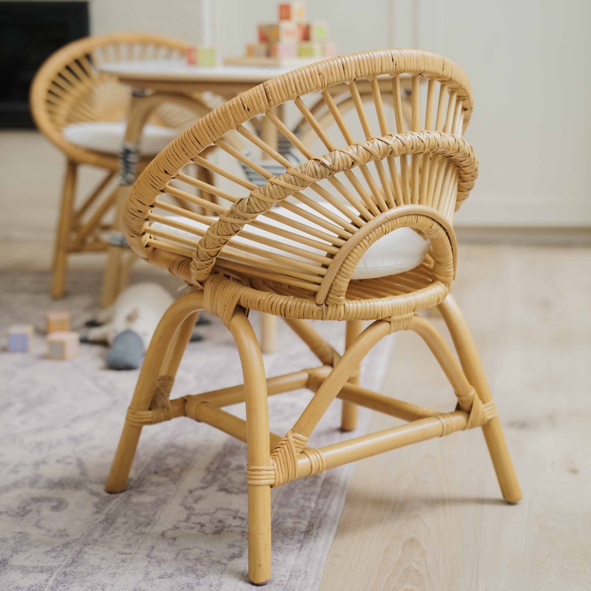 Natural handcrafted rattan Maya Kids Chairs by MOMIJI styled with a matching Aulia Kids Table in a softly lit room.