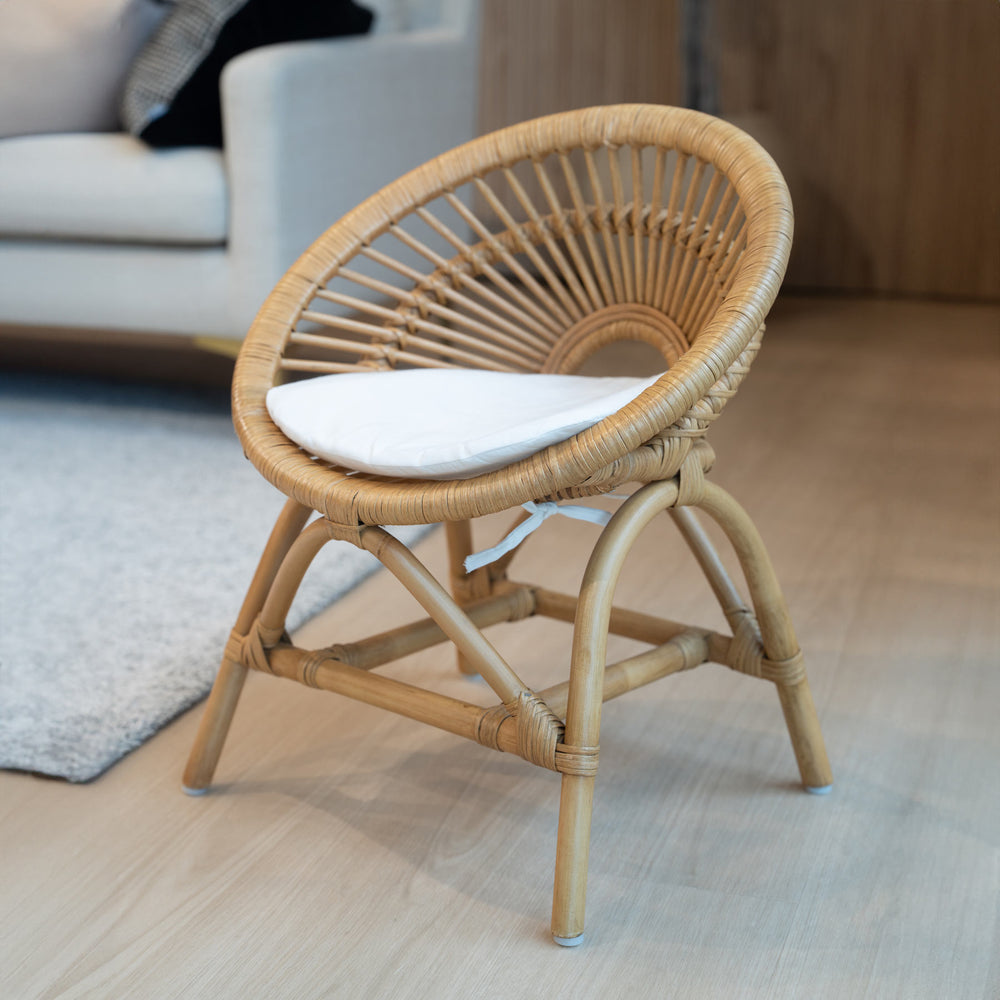 Angled view of the Maya Kids Chair by MOMIJI in a room with a sofa and rug.