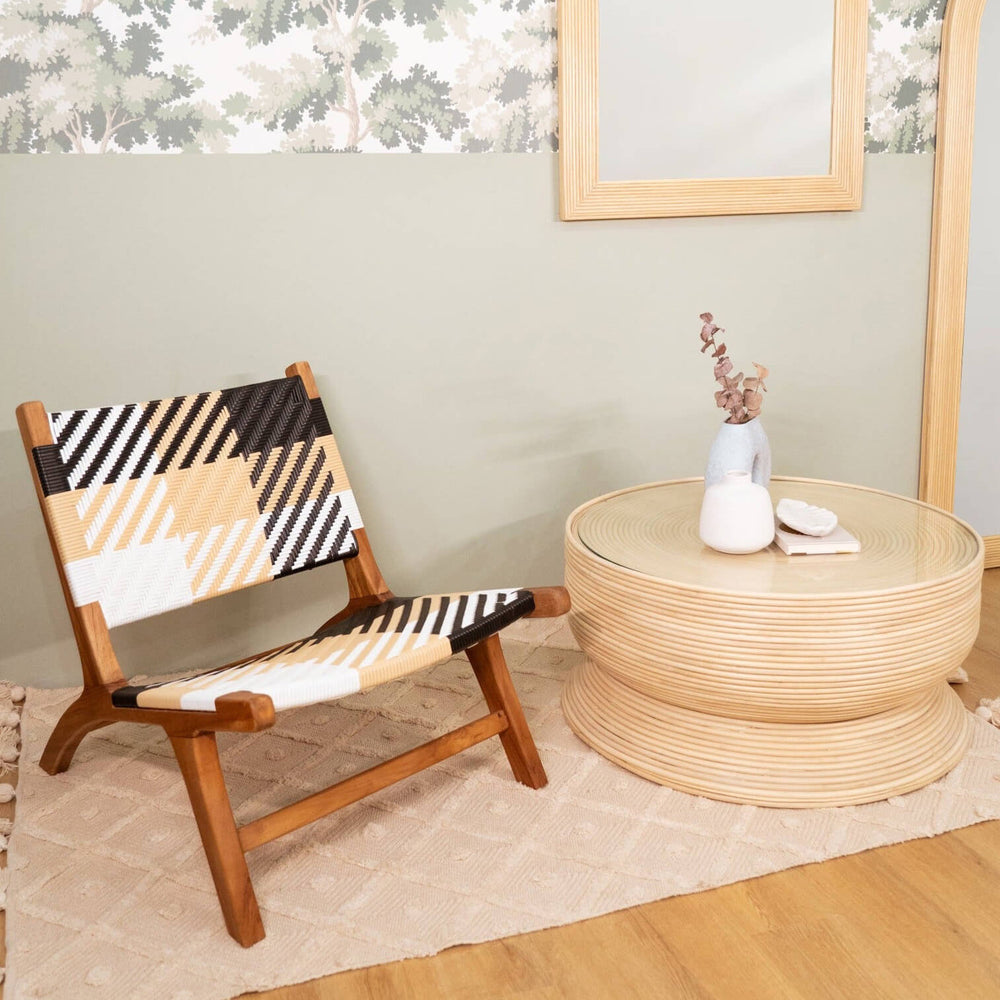 Mila Plaid Lounge Chair by MOMIJI on a white rug beside a coffee table with decorative elements.