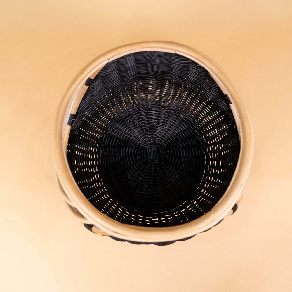 Interior view of the handcrafted rattan wicker Nikko Basket by MOMIJI featuring black weaving with natural rattan accents, showing its storage space.