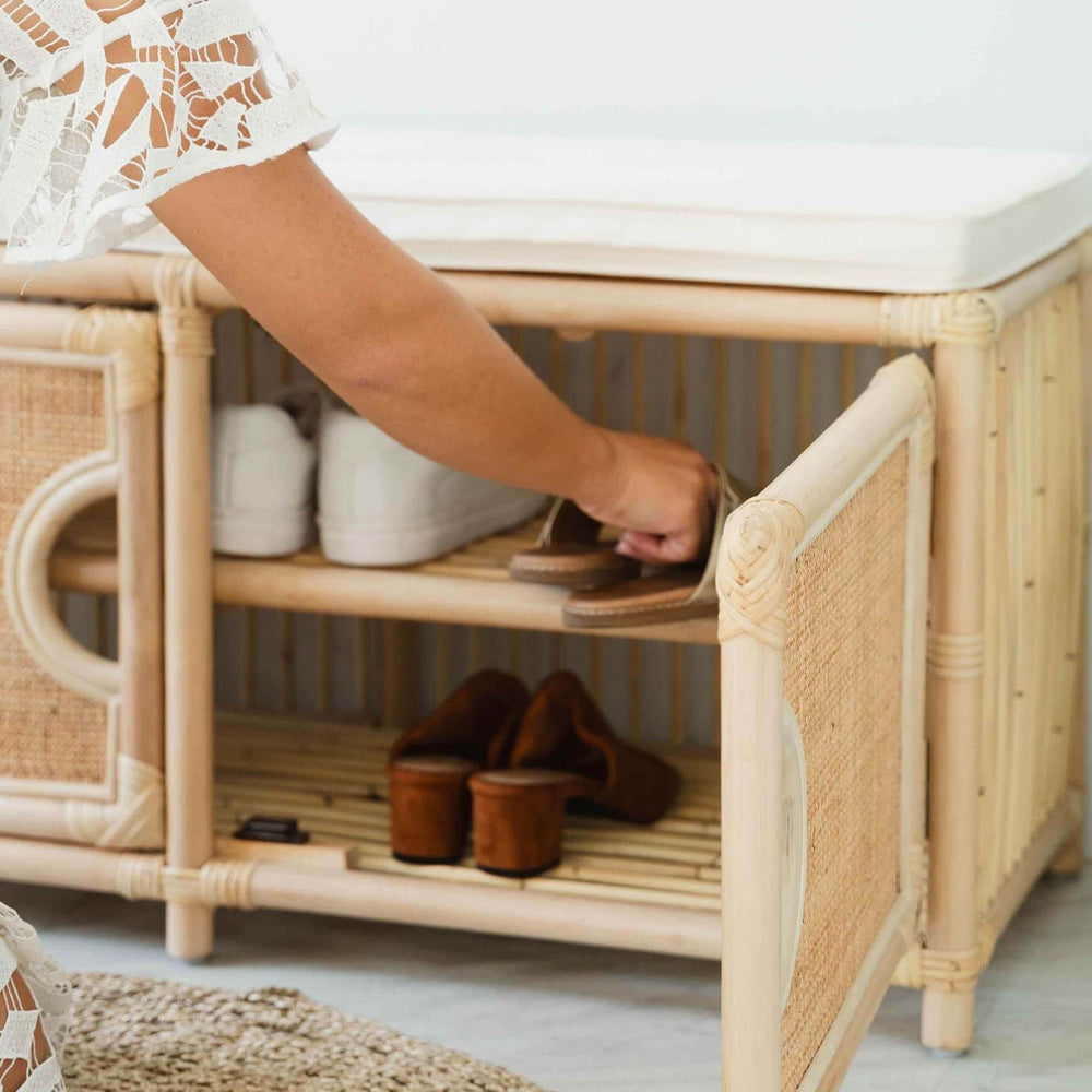 Woman storing sandals on the Palma Shoe Cabinet by MOMIJI alongside white shoes and brown heels.