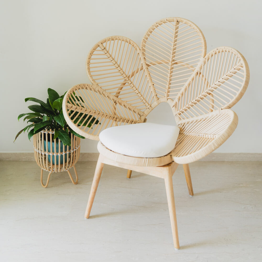 Handcrafted rattan Petal Chair by MOMIJI with a white cushion, styled in a cozy living room with a potted plant.