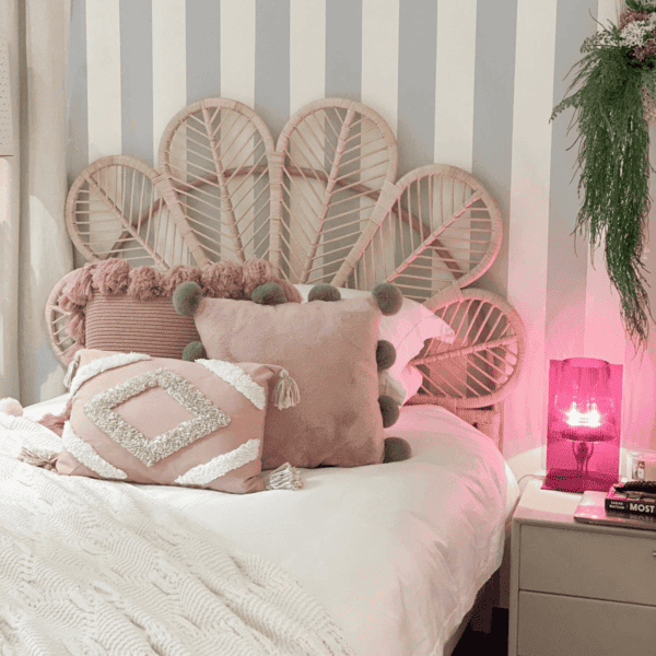 Petal Headboard by MOMIJI installed on a single bed in a cozy bedroom setting, highlighting its handwoven rattan petal shape.