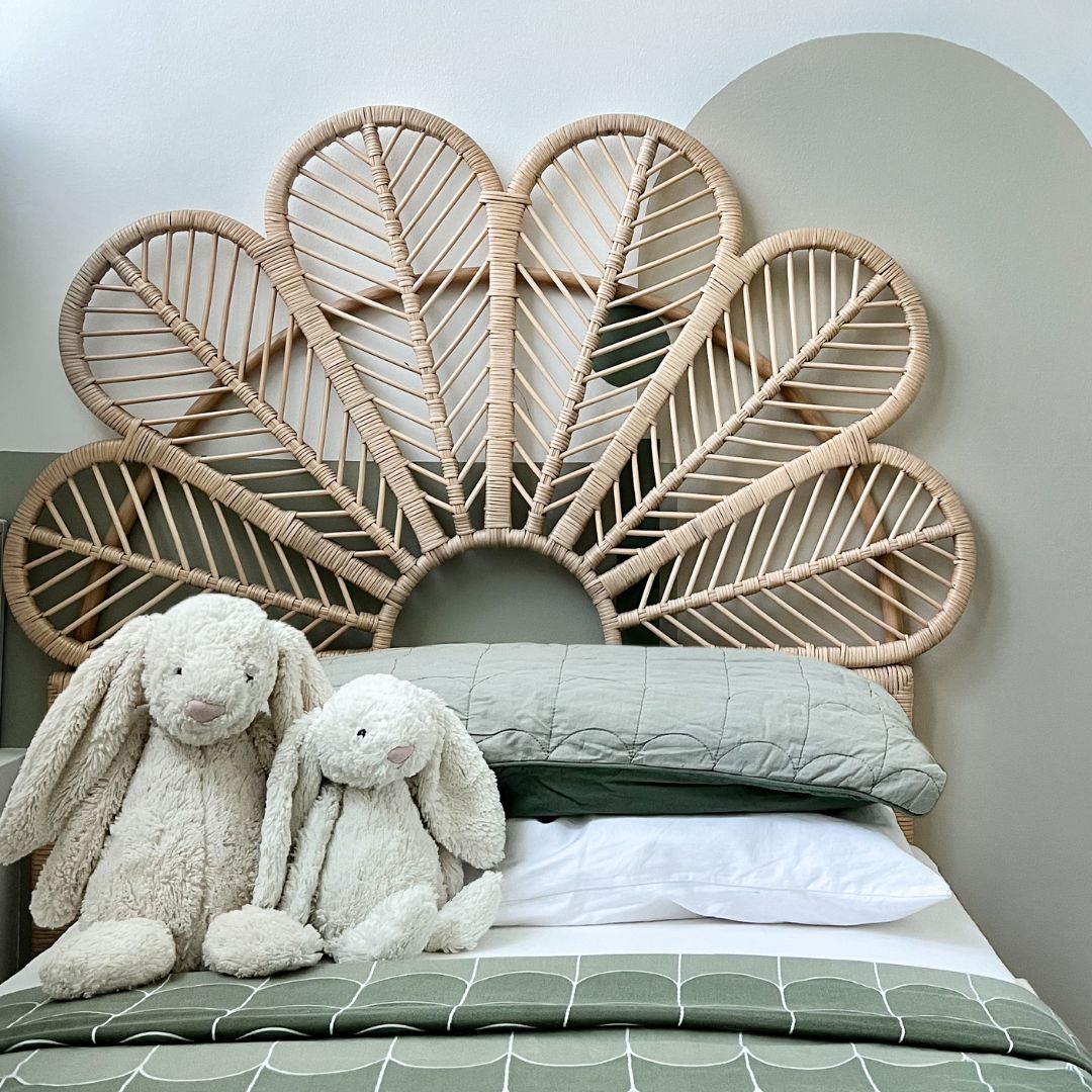 Petal Headboard by MOMIJI styled in a kids’ bedroom, featuring a full handwoven rattan headboard shaped like flower petals, with bunny dolls on the bed.