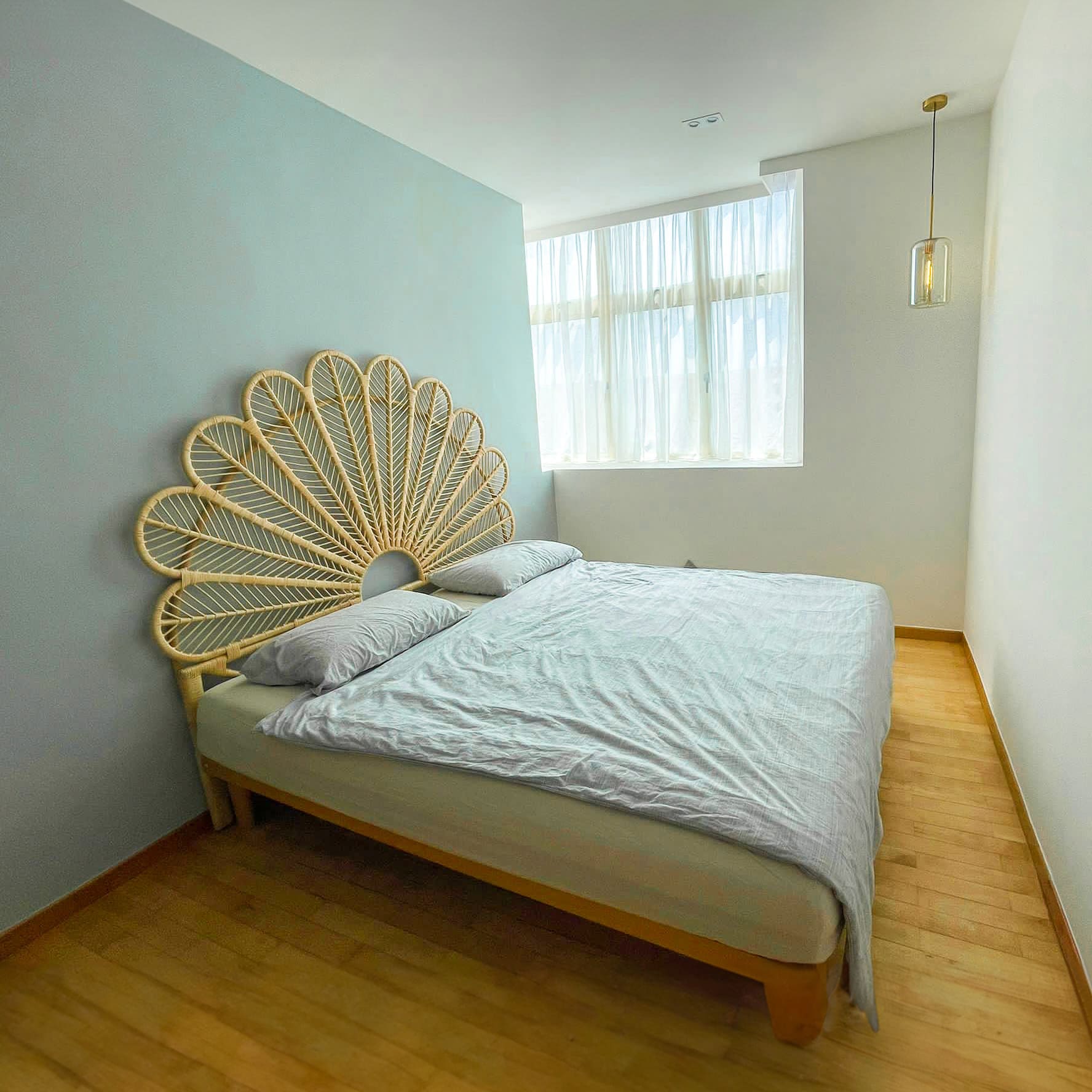 Petal Headboard by MOMIJI installed on a large bed in a styled bedroom, showcasing the statement petal-inspired rattan design.