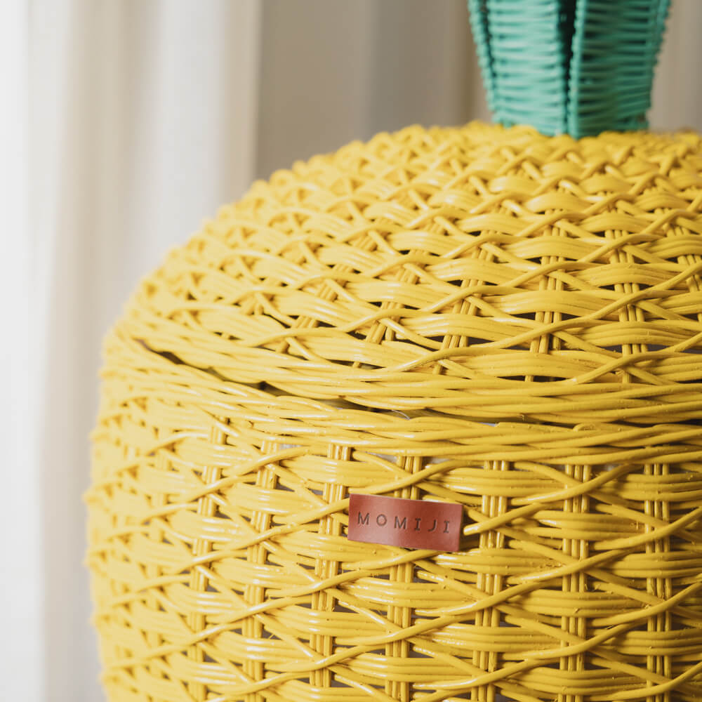 Close up MOMIJI logo on a yellow Pineapple Rattan Storage Basket.