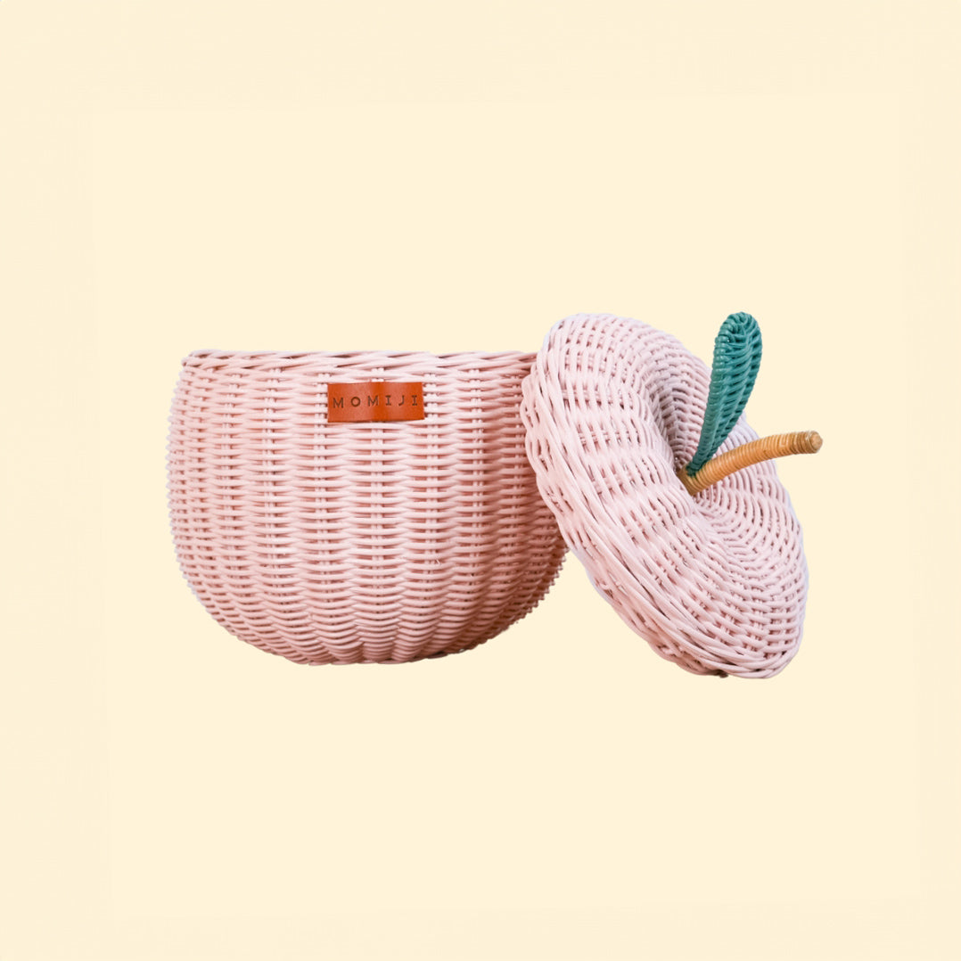 Front view of the Apple Rattan Storage Basket by MOMIJI in pink, small size, with the lid open.