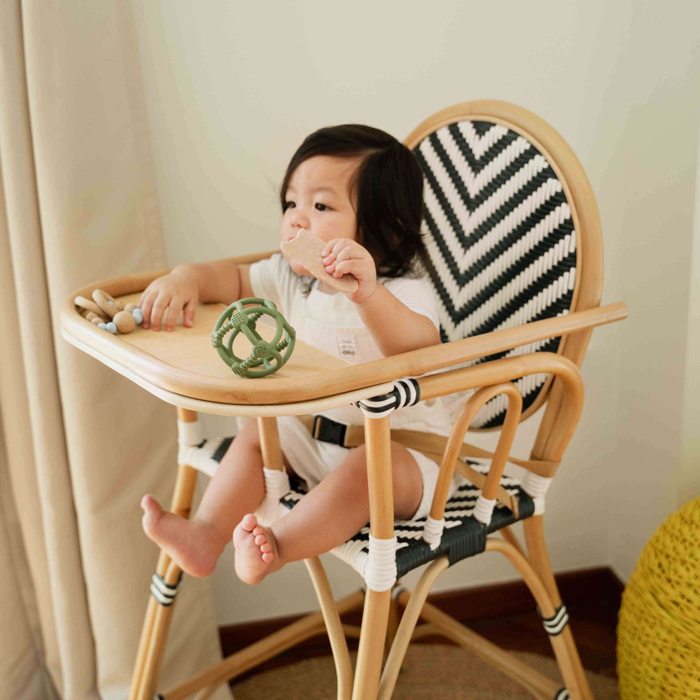 Child eating snacks and playing on the tray of the Tumbuh Kids High Chair by MOMIJI.