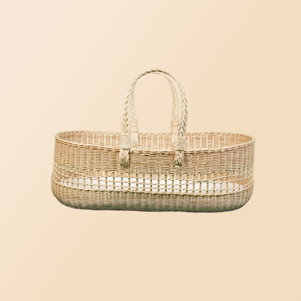 Side view of the Vera Moses Basket by MOMIJI without the cushion, showcasing the fully handwoven rattan pattern throughout the basket and handles.