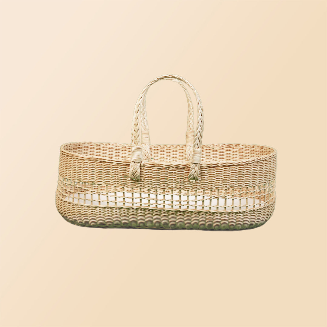 Side view of the Vera Moses Basket by MOMIJI without the cushion, showcasing the fully handwoven rattan pattern throughout the basket and handles.