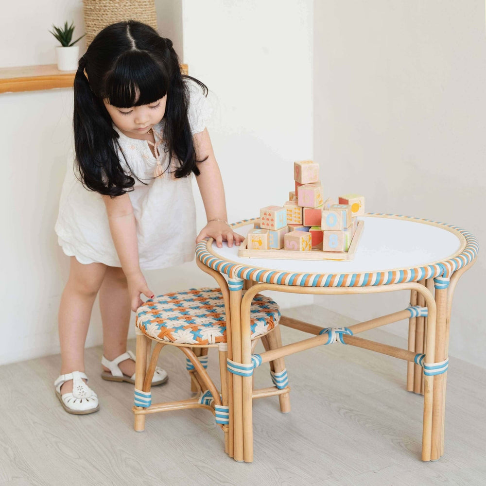 Young girl playing with colorful blocks on a Xander Kids Table and stool set by MOMIJI