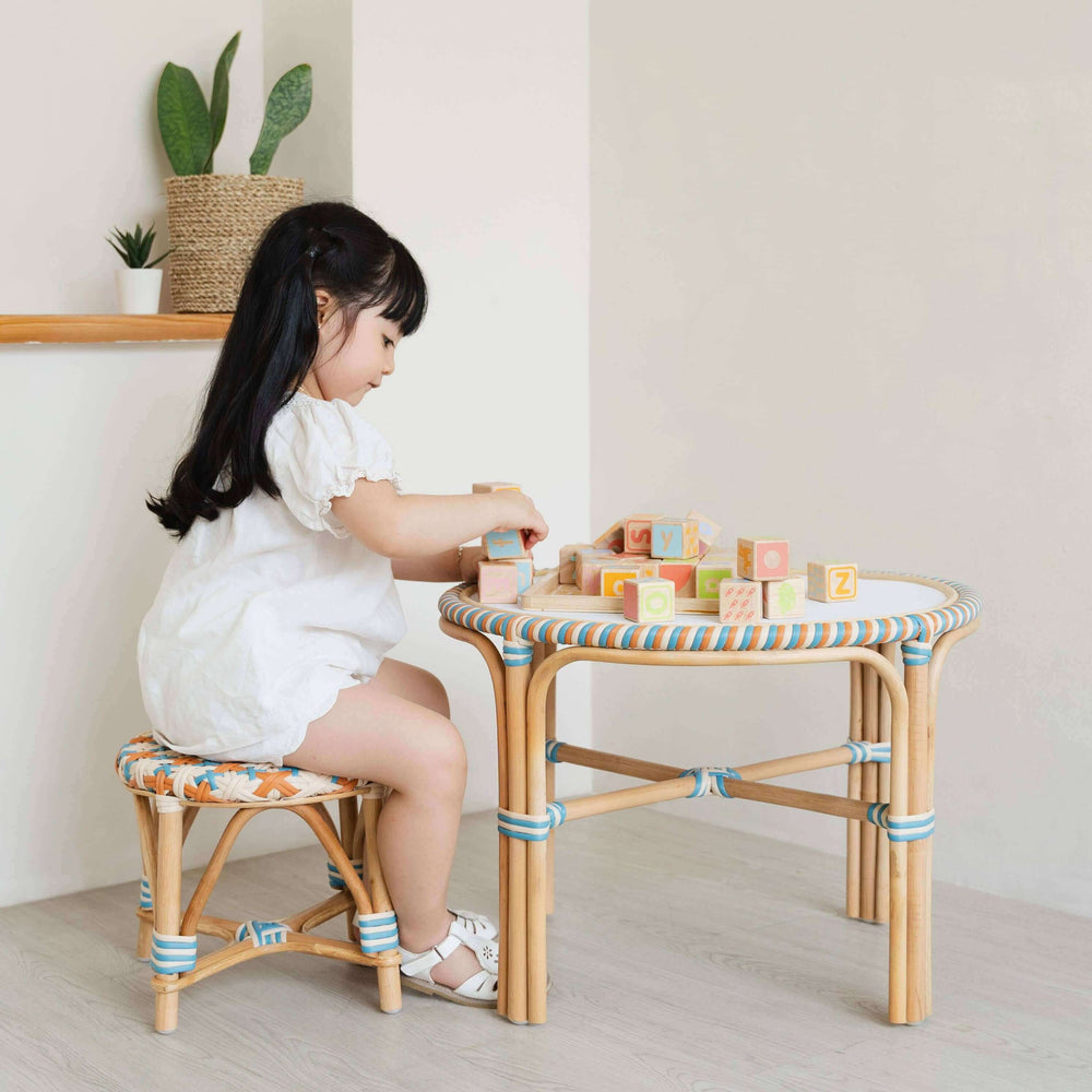 Child sit in stool while playing with colorful blocks at a Xander Kids Table in a Play room with indoor plants.