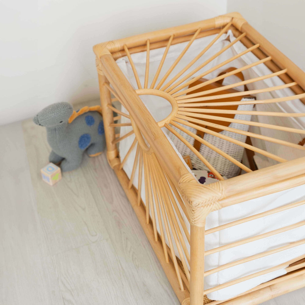 Angled view of the wicker Xander Trunk by MOMIJI inside filled with children’s toys, styled indoors.