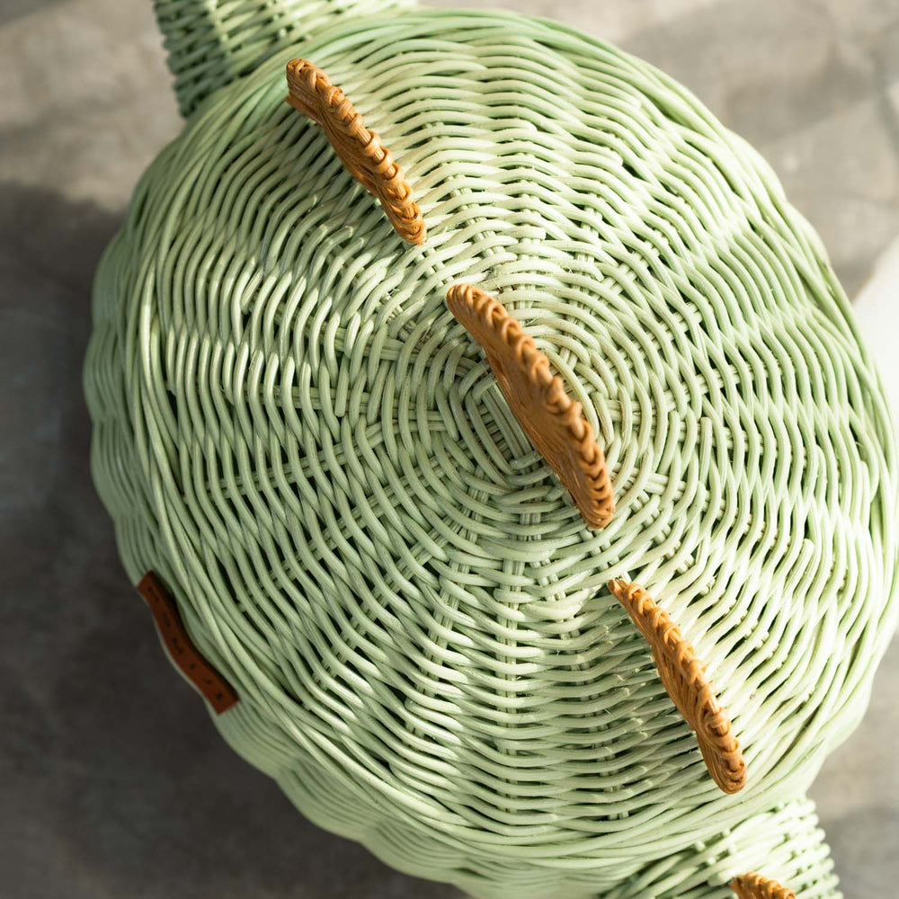 Top view of the medium size handcrafted dinosaur storage basket by MOMIJI in mint green rattan, showing the tidy and secure woven rattan construction.