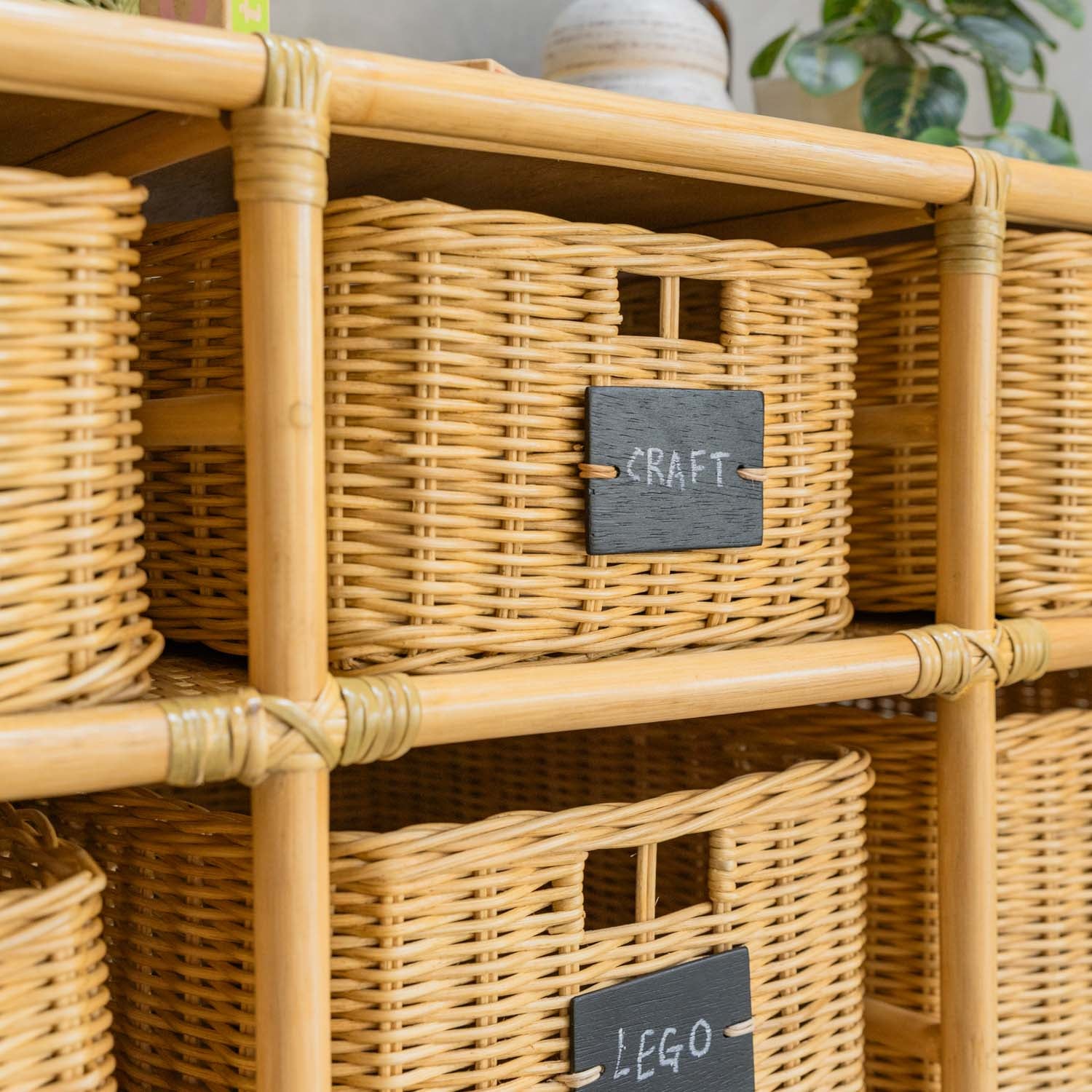 Close-up of Graha Montessori wicker storage baskets by MOMIJI with blackboard labels, highlighting the woven texture and label detail.
