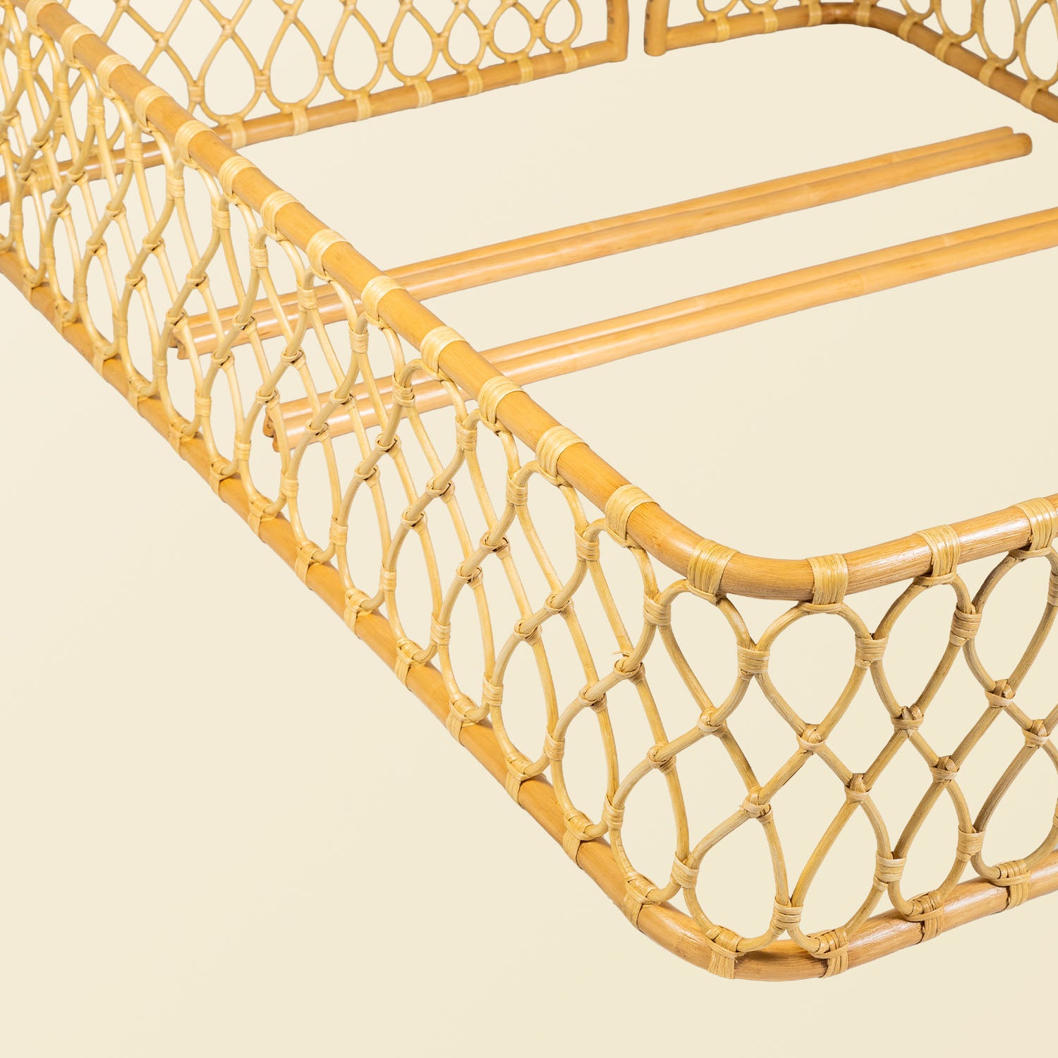 Close-up detail of the corner joint on the handcrafted rattan wicker Layla Montessori floor bed frame by MOMIJI with wicker detailing in beige natural rattan.