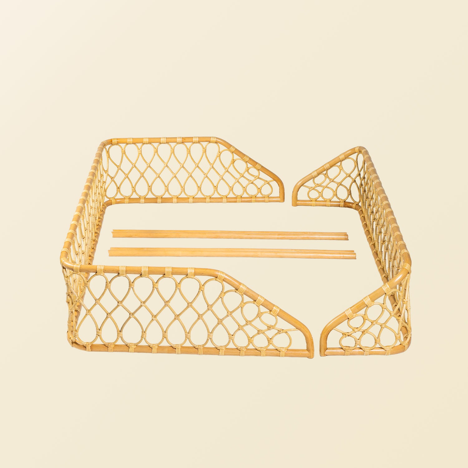 Unassembled of the handcrafted Layla Montessori floor bed frame by MOMIJI in beige natural rattan with chopsticks, showing the full wicker and rattan structure.