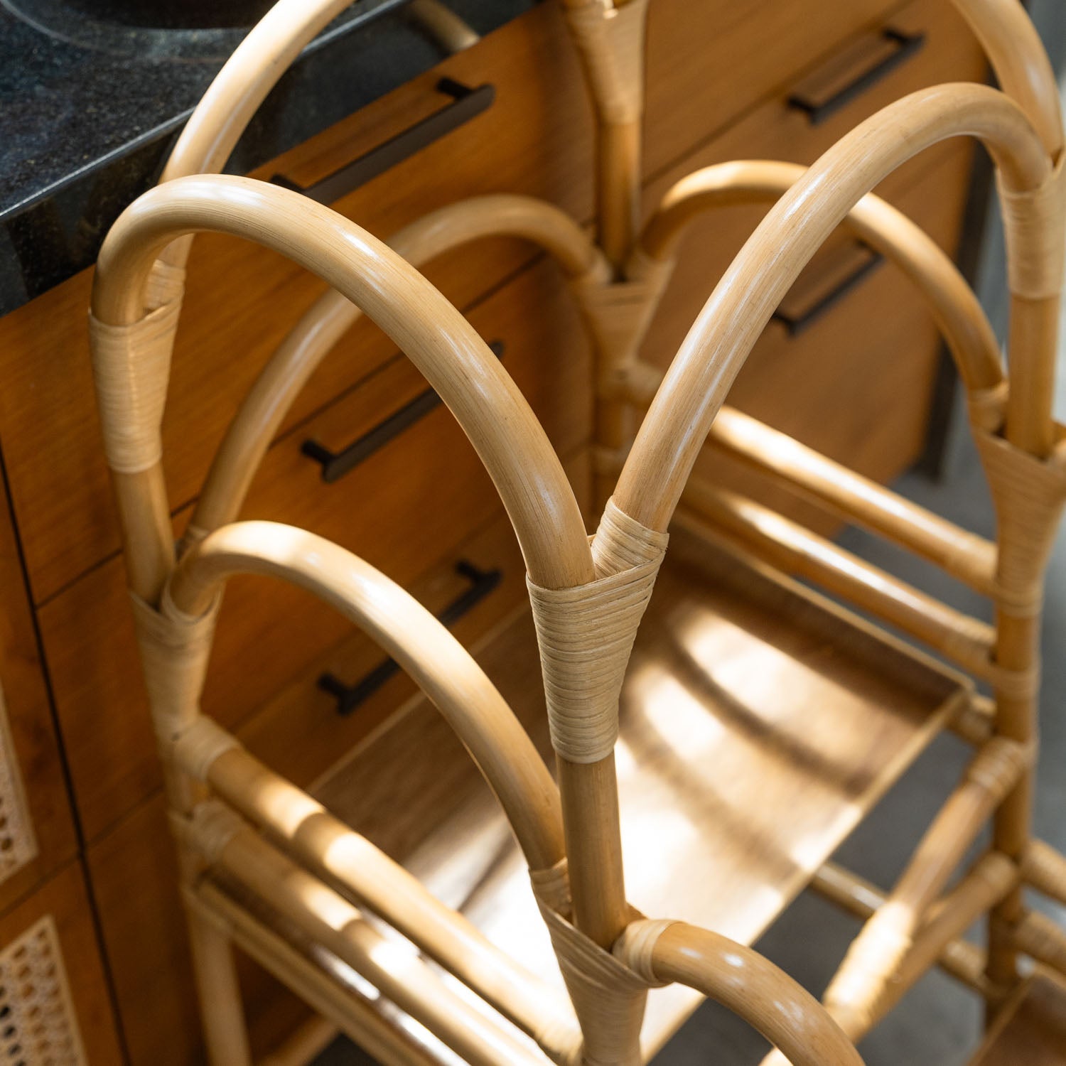 Top view close-up of a handcrafted rattan wicker leon montessori learning tower by MOMIJI, showing the side handle and wrapped joints for strength.